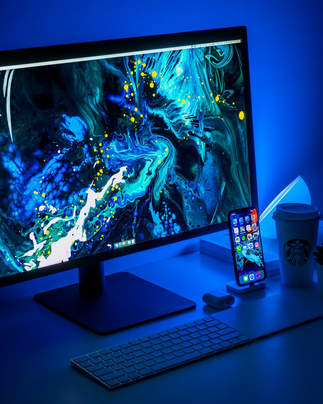 A monitor displaying a colorful landscape in a blue-lit setup.