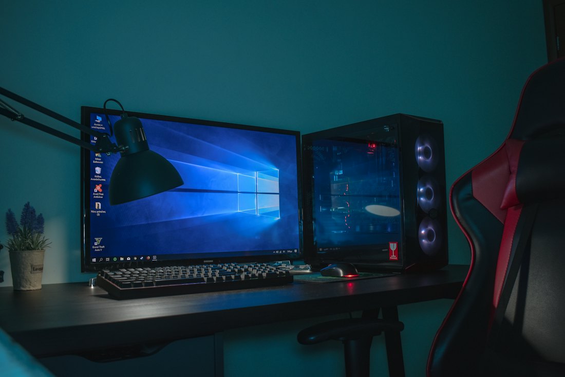 A gaming desktop with a monitor, keyboard and illuminated computer tower.